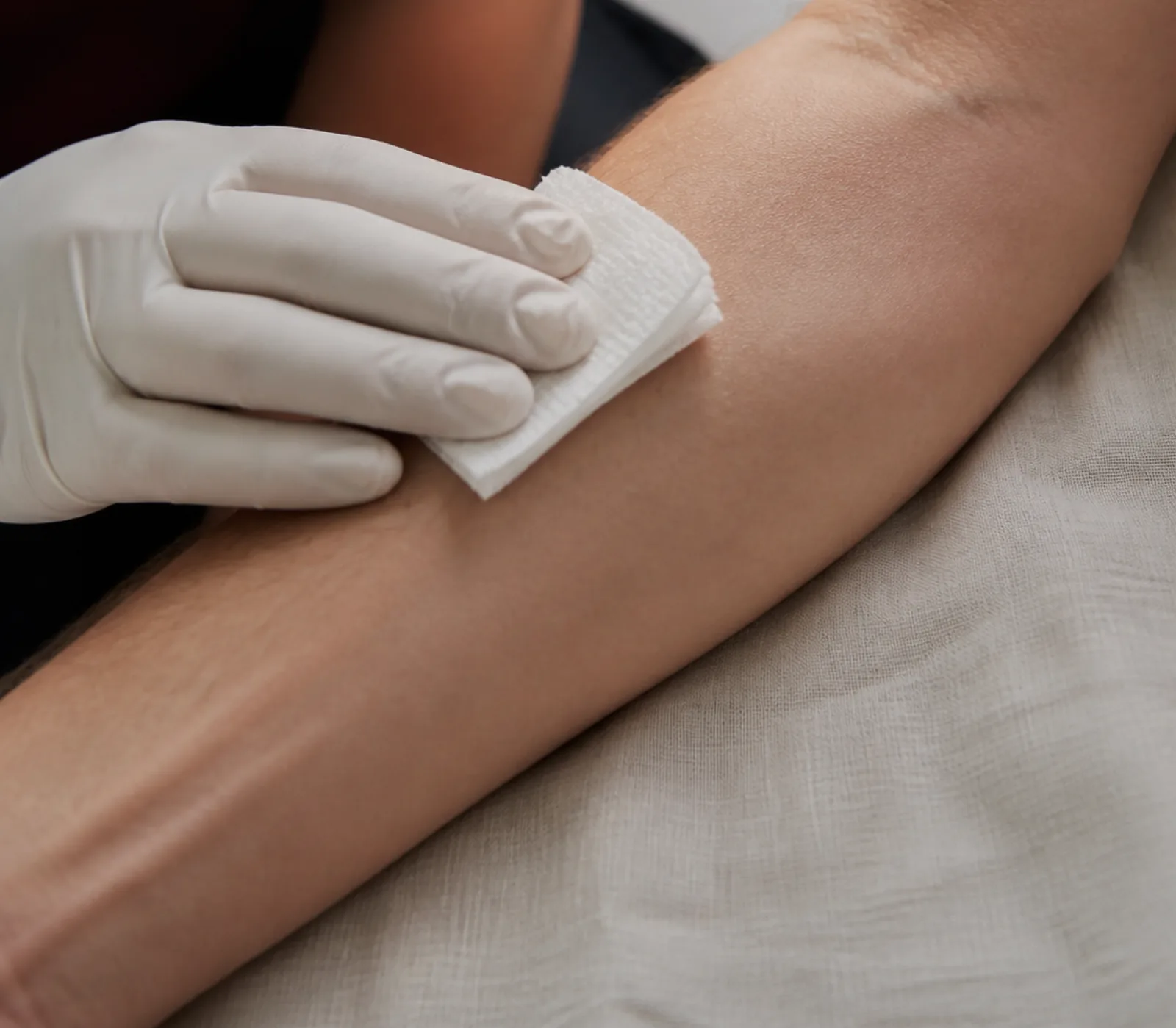 Gauze pressed to a forearm after a blood sample